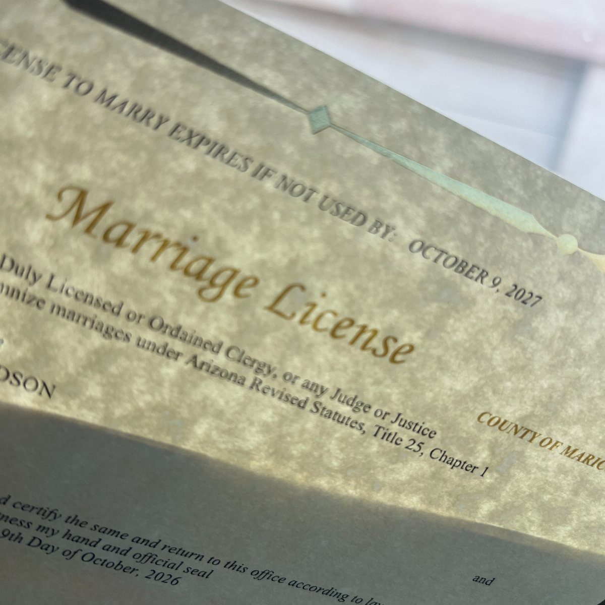 Marriage license document with elegant cursive text on textured beige paper.
