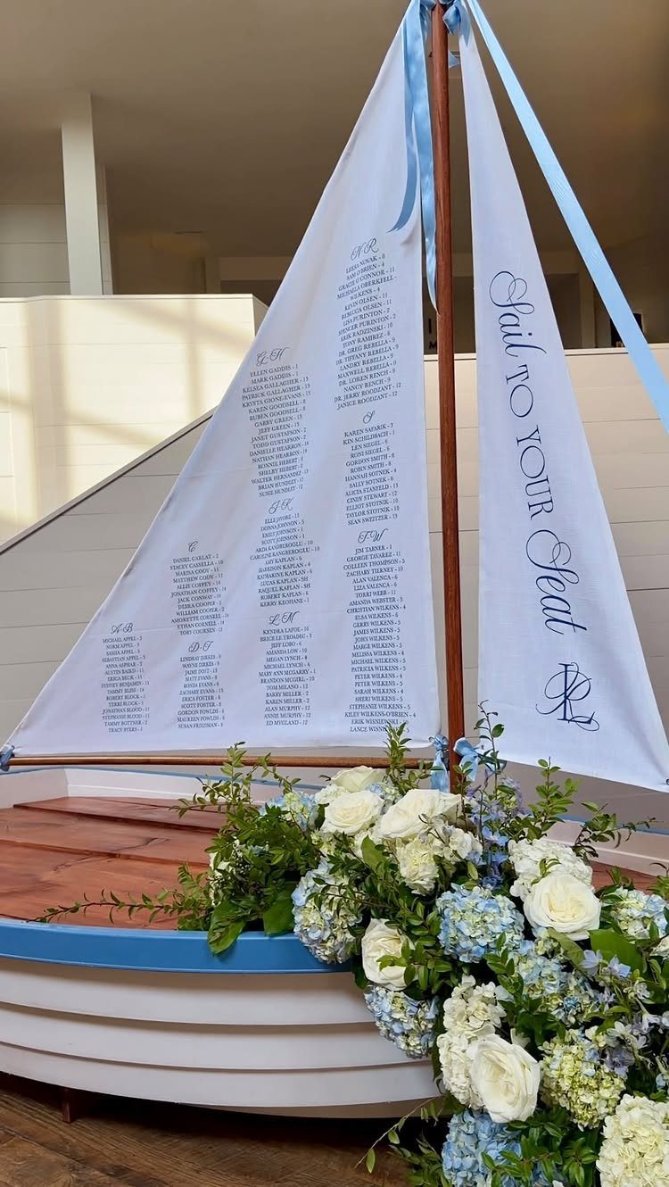 White boat with blue and white flowers and a sail seating chart.