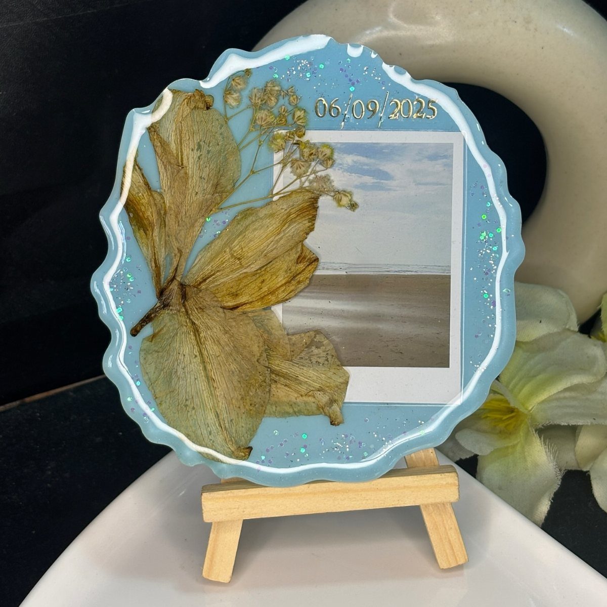 Resin frame with dried leaves and beach photo on a wooden easel