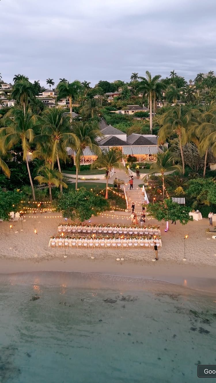 Beach wedding seating arrangement on the sand in front of a beachfront resort.