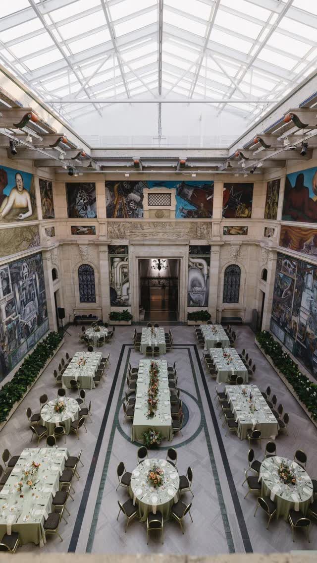 Grand museum hall with banquet tables set for a formal event under a skylight