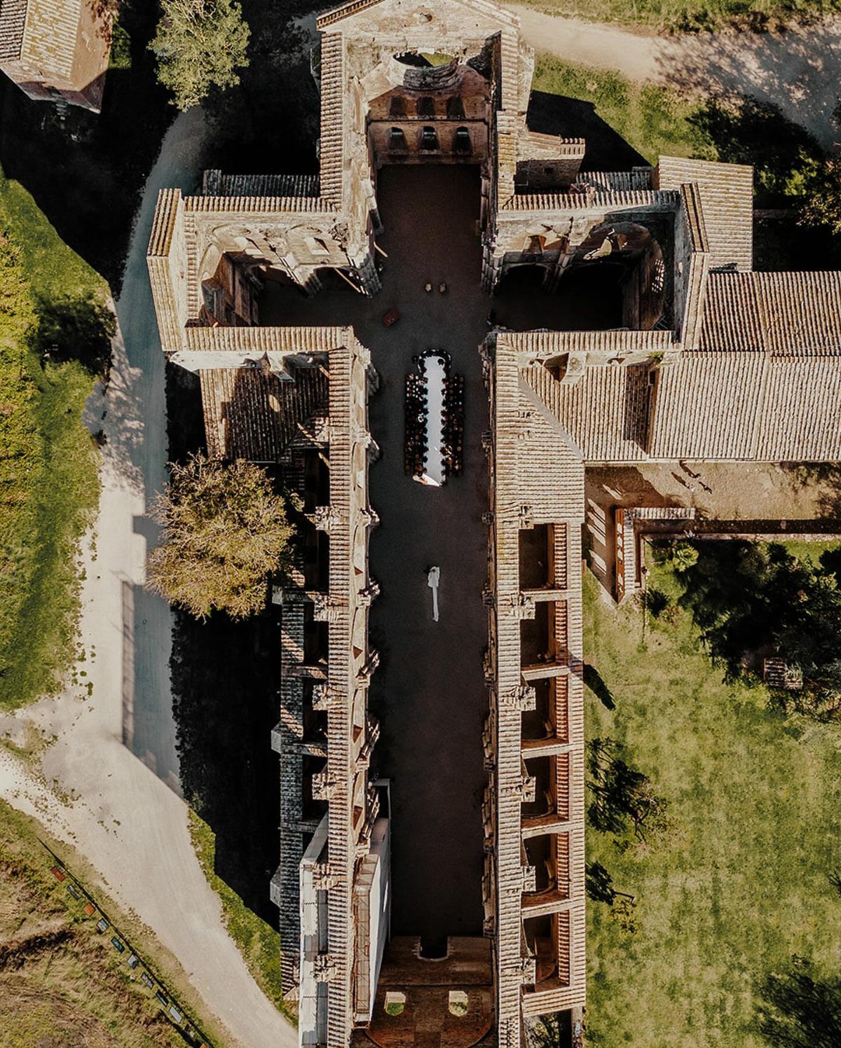 Aerial view of a long dining table set within ancient stone ruins.