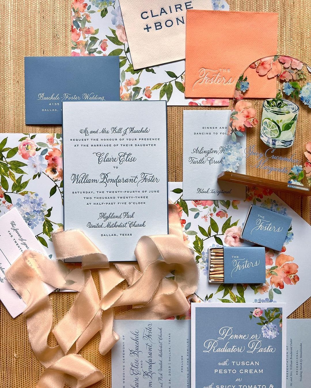 Wedding invitation set with navy and blush floral cards, translucent acrylic, and satin ribbon.