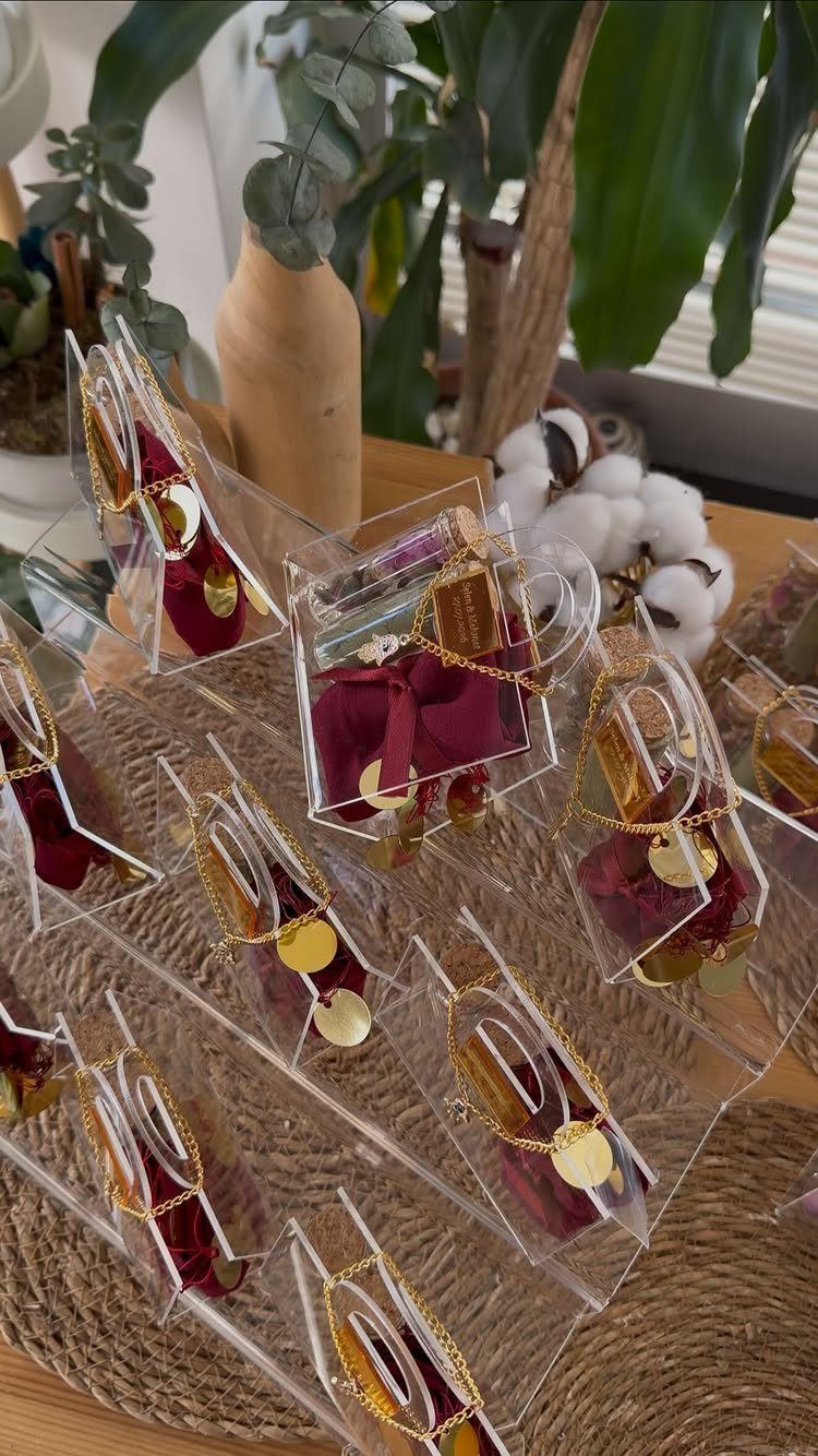 Gold necklaces with circular pendants in clear plastic boxes on a woven mat