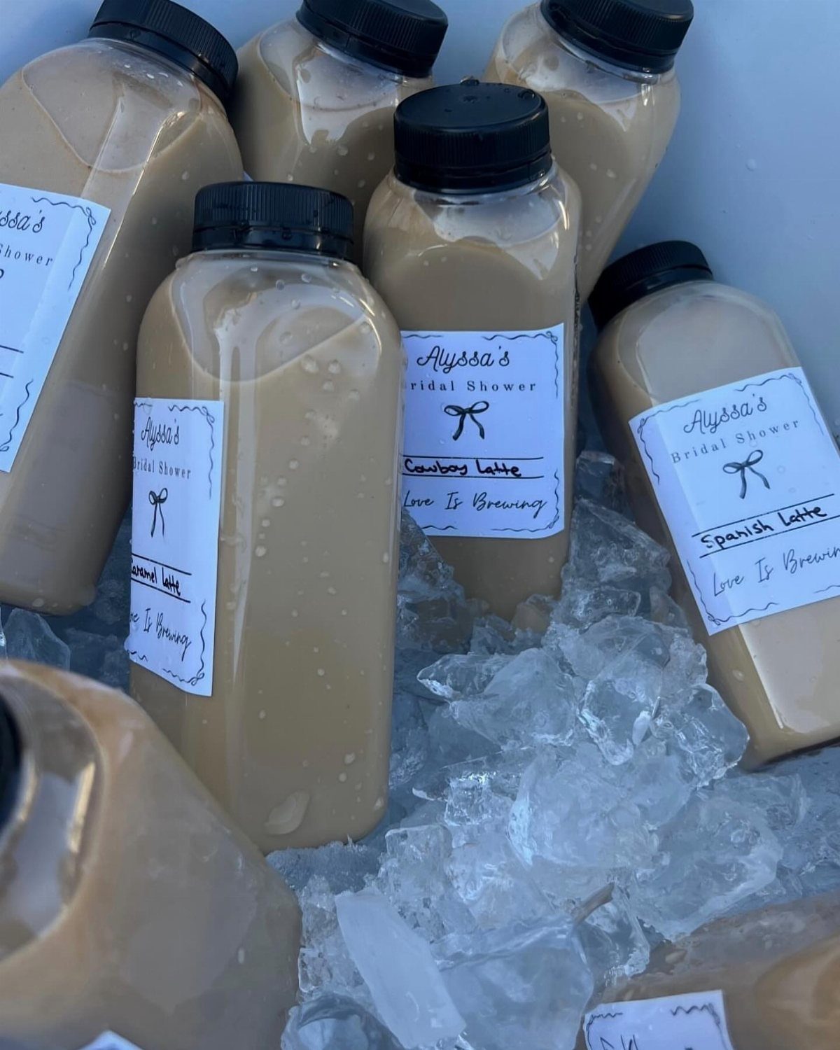 Bottles of coffee drinks with bridal shower labels chilled on a bed of ice