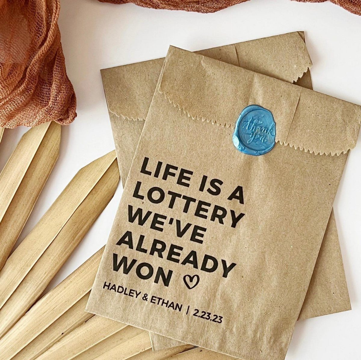 Brown kraft paper envelopes with lottery themed text and a blue wax seal.