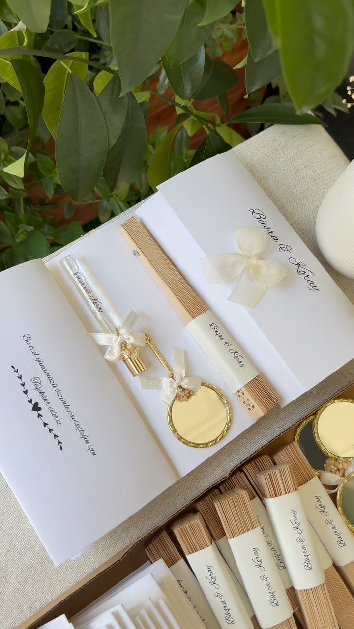 Wooden pens and small gold mirrors with white bows in a gift box.