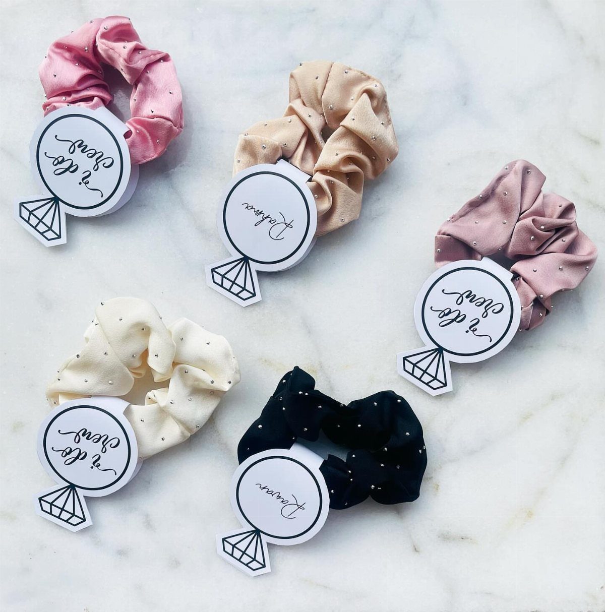Satin hair scrunchies in various colors attached to bridal shower gift tags.