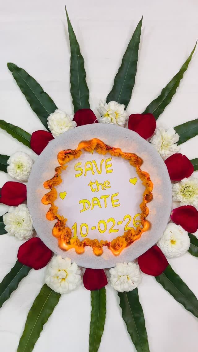 Burnt edge save the date card surrounded by red petals and white flowers
