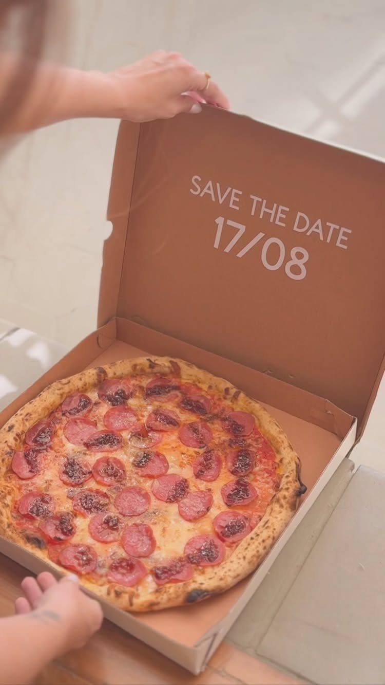 Pepperoni pizza in a cardboard box with save the date printed on lid