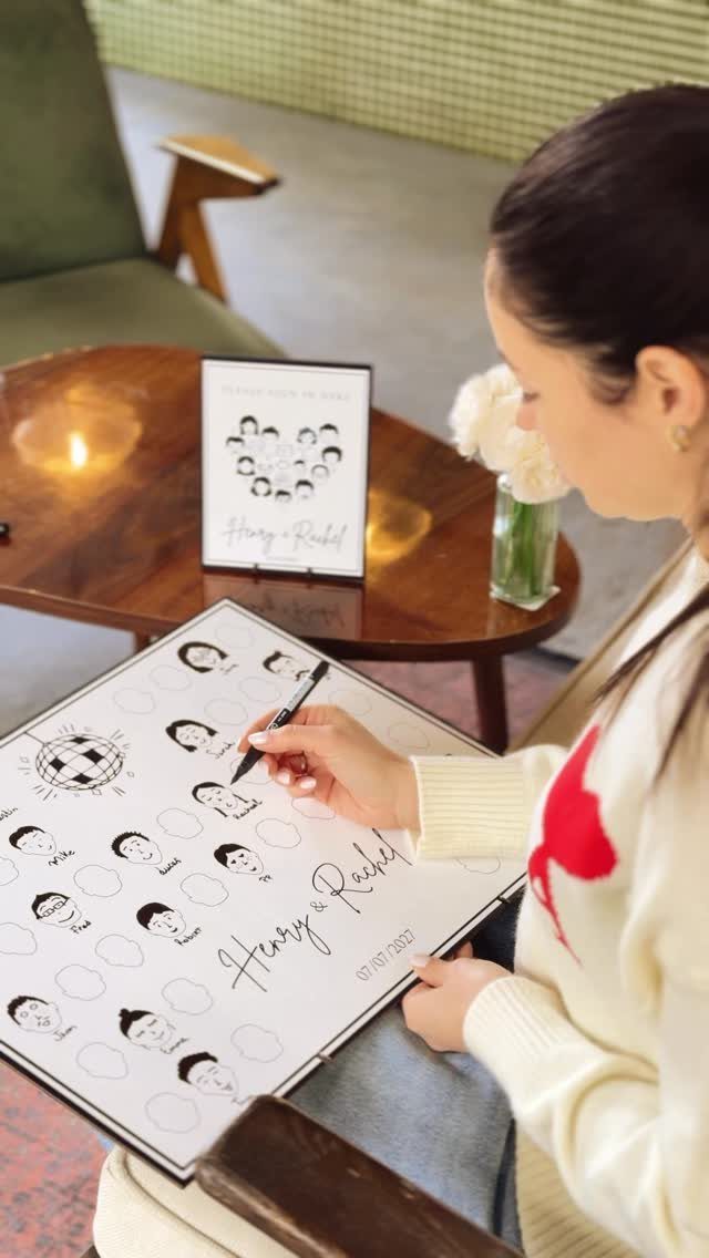 Woman drawing a face on a Draw Yourself Wedding Guest Book board.