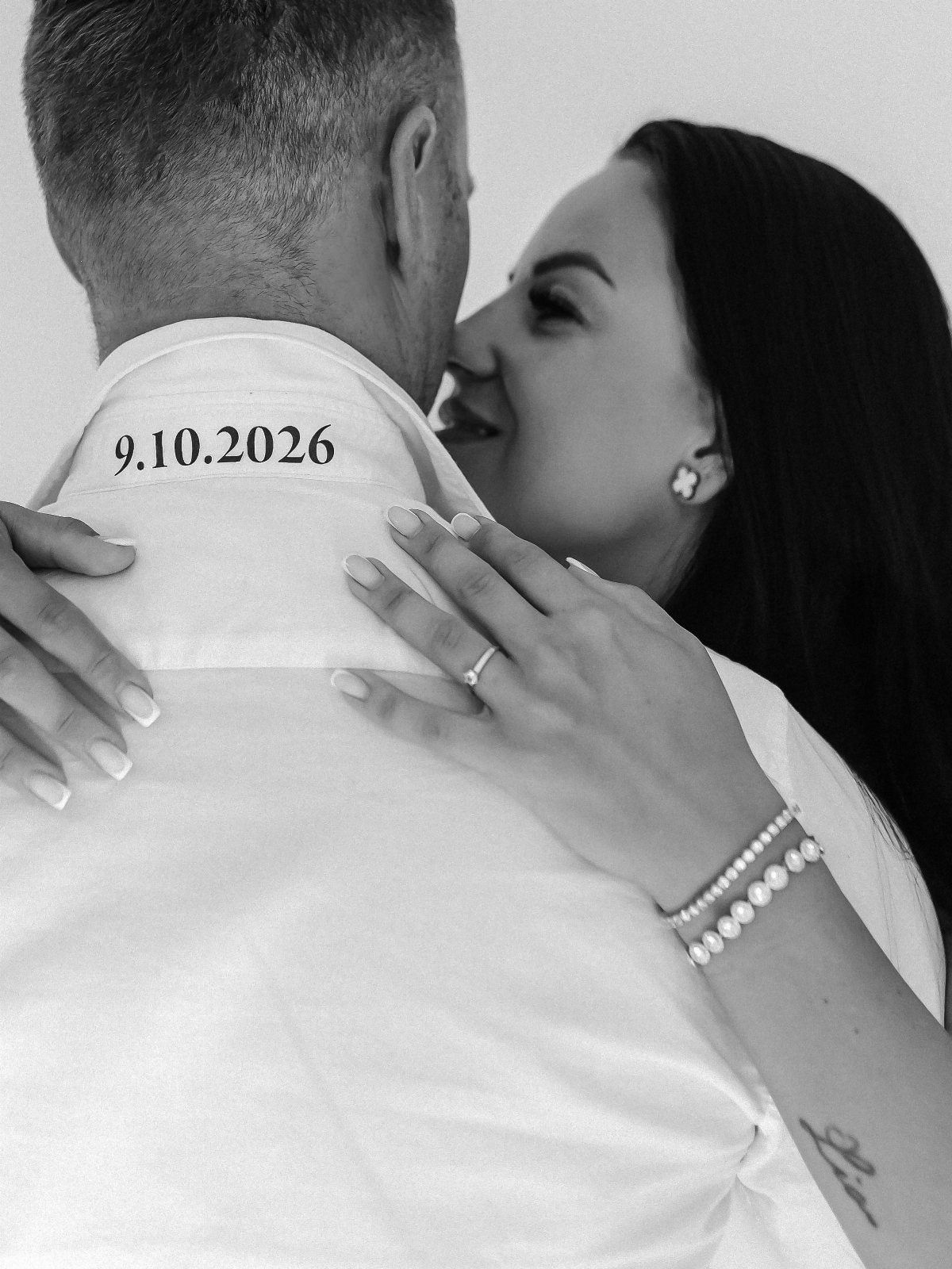 Couple in black and white portrait with wedding date printed on man's collar
