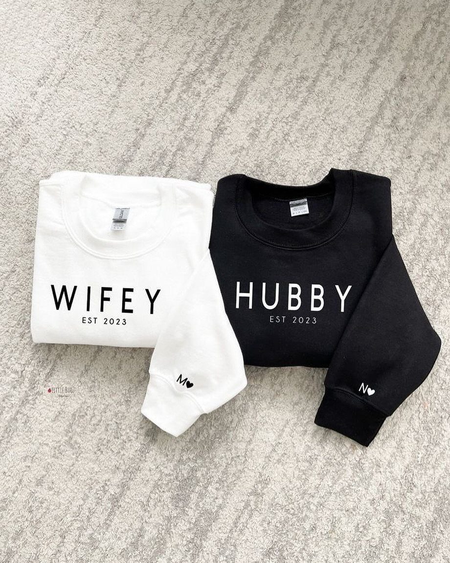 Matching white and black sweatshirts with Wifey and Hubby text on grey background