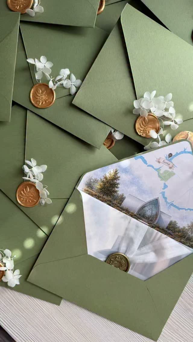Olive green envelopes with gold wax seals and a watercolor illustration card inside.