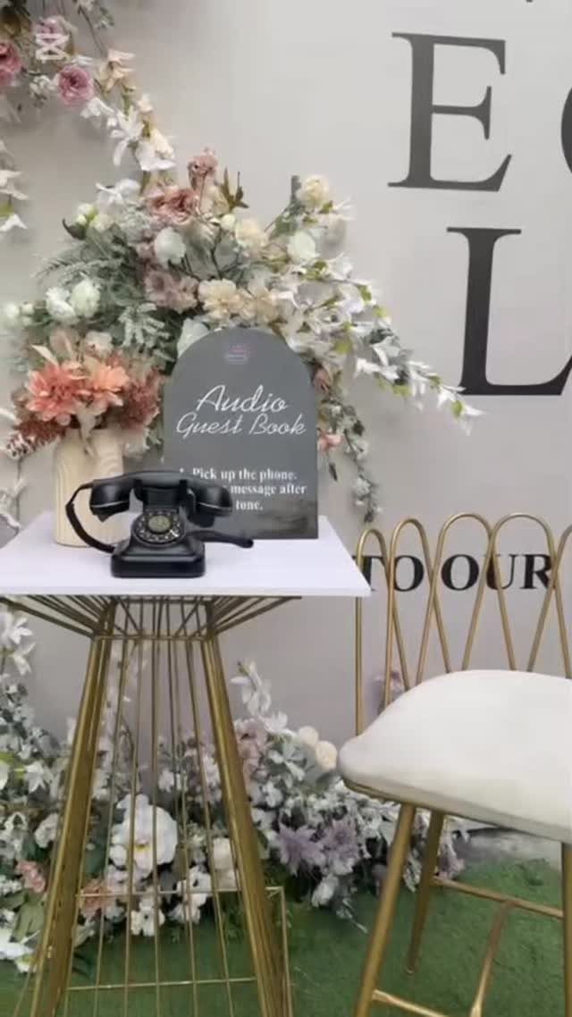 Vintage black rotary phone on a gold table with Audio Guest Book sign.
