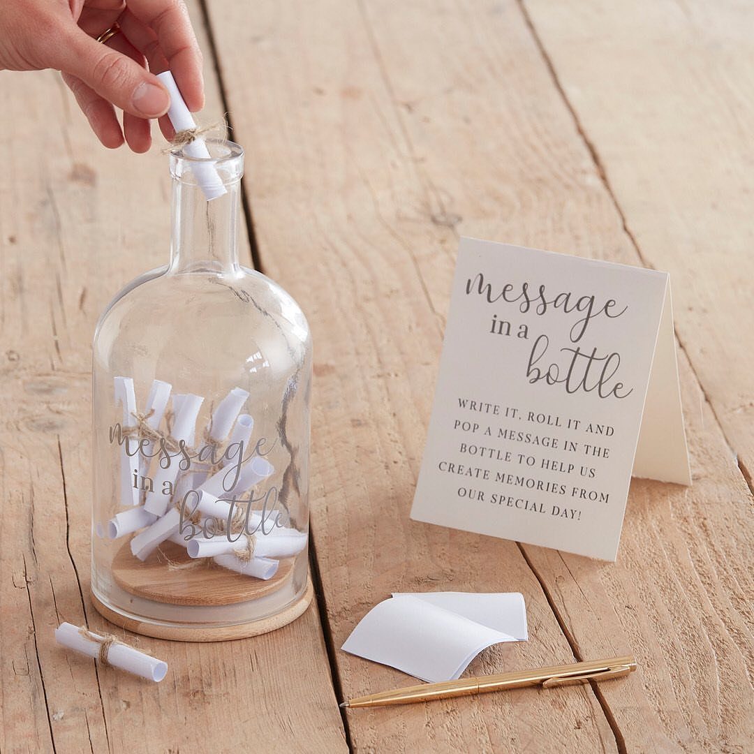 Hand placing a rolled paper note into a glass message in a bottle