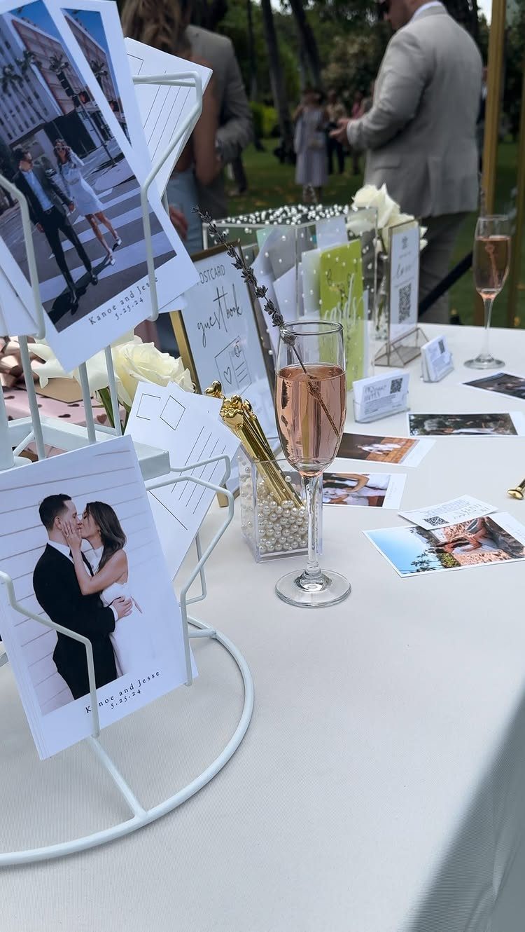 Postcard guest book station with photo cards in wire holders on a white table