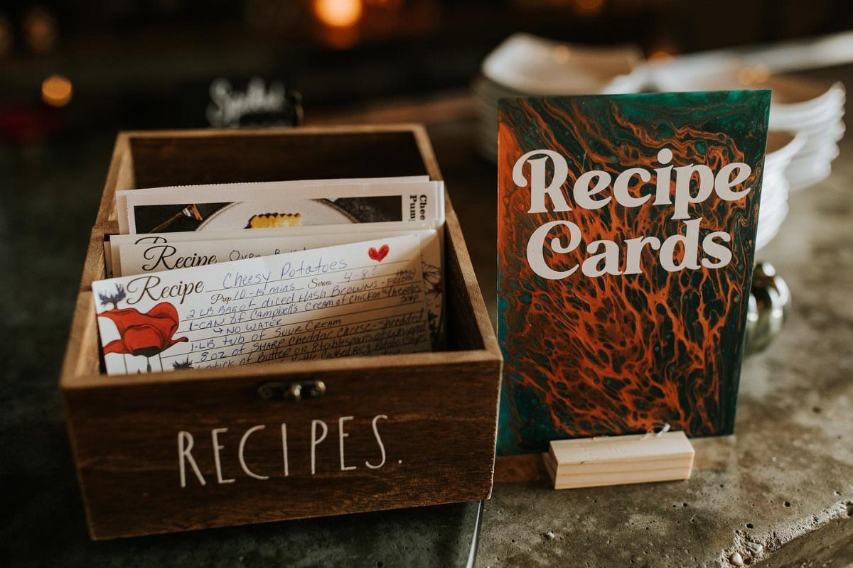 Wooden recipe box with handwritten cards and a colorful Recipe Cards sign.
