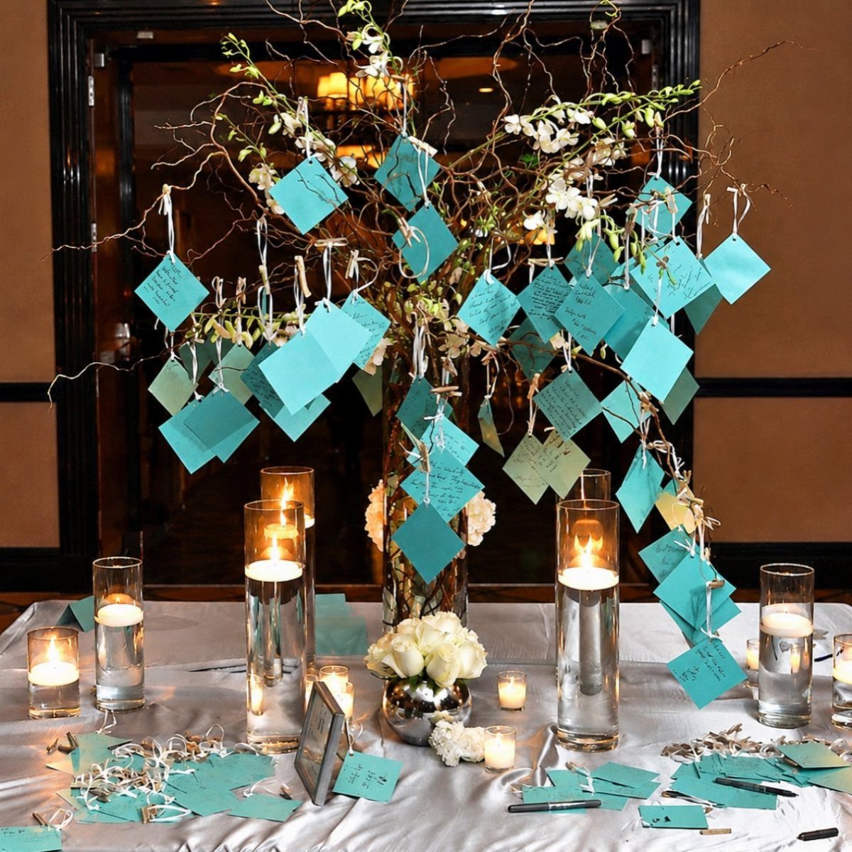 Turquoise message cards hanging from a decorative branch tree with floating candles.