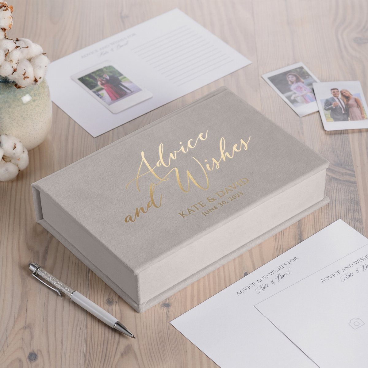 Grey advice and wishes box with cards and a pen on wooden table