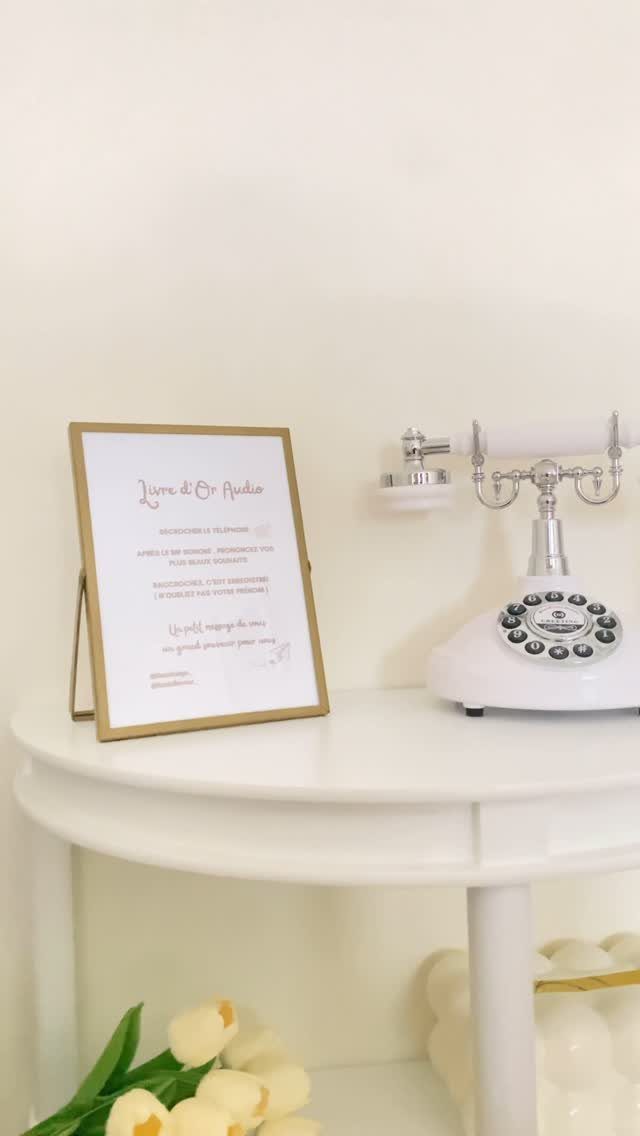Vintage white rotary telephone and framed sign on a white table with tulips.
