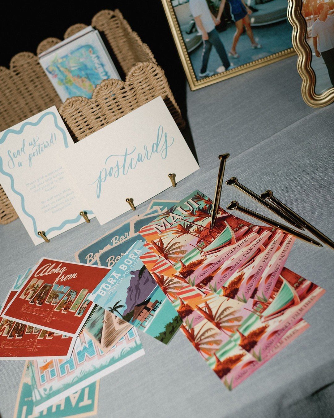 Vintage postcards and a sign on a grey table for a guest book.