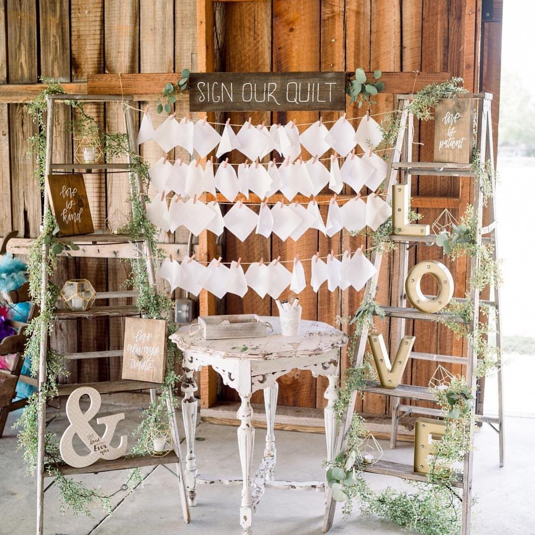 White fabric squares hanging for guests to sign as a quilt guest book.