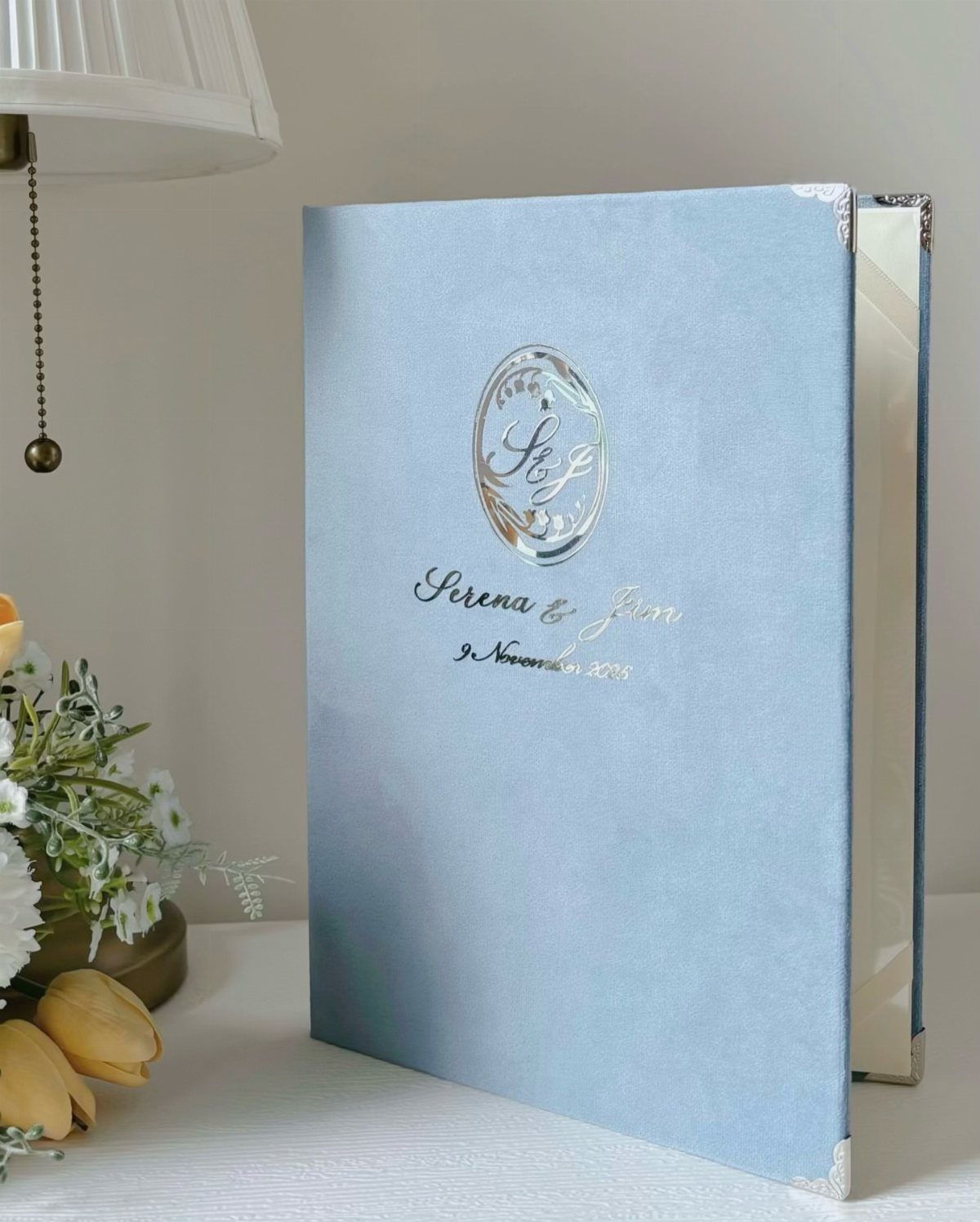 Dusty blue linen guest book with silver foil names and date on cover.