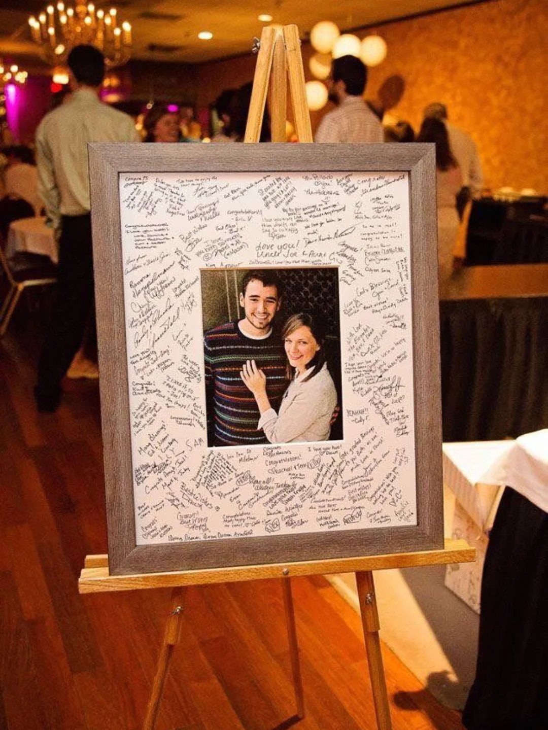 Framed photo of a couple with guest signatures on the white mat border.