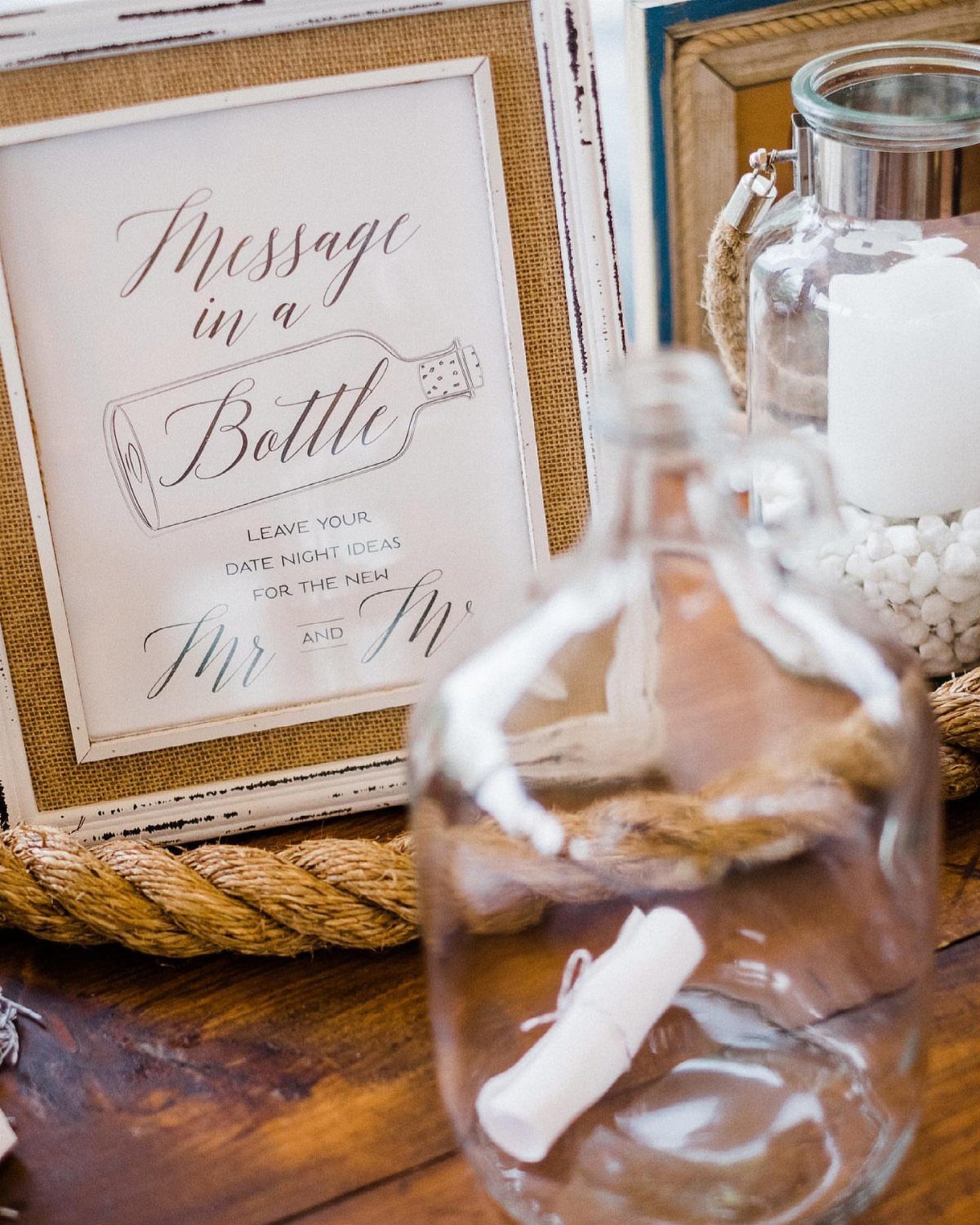 Framed Message in a Bottle sign next to a glass bottle with rolled paper.