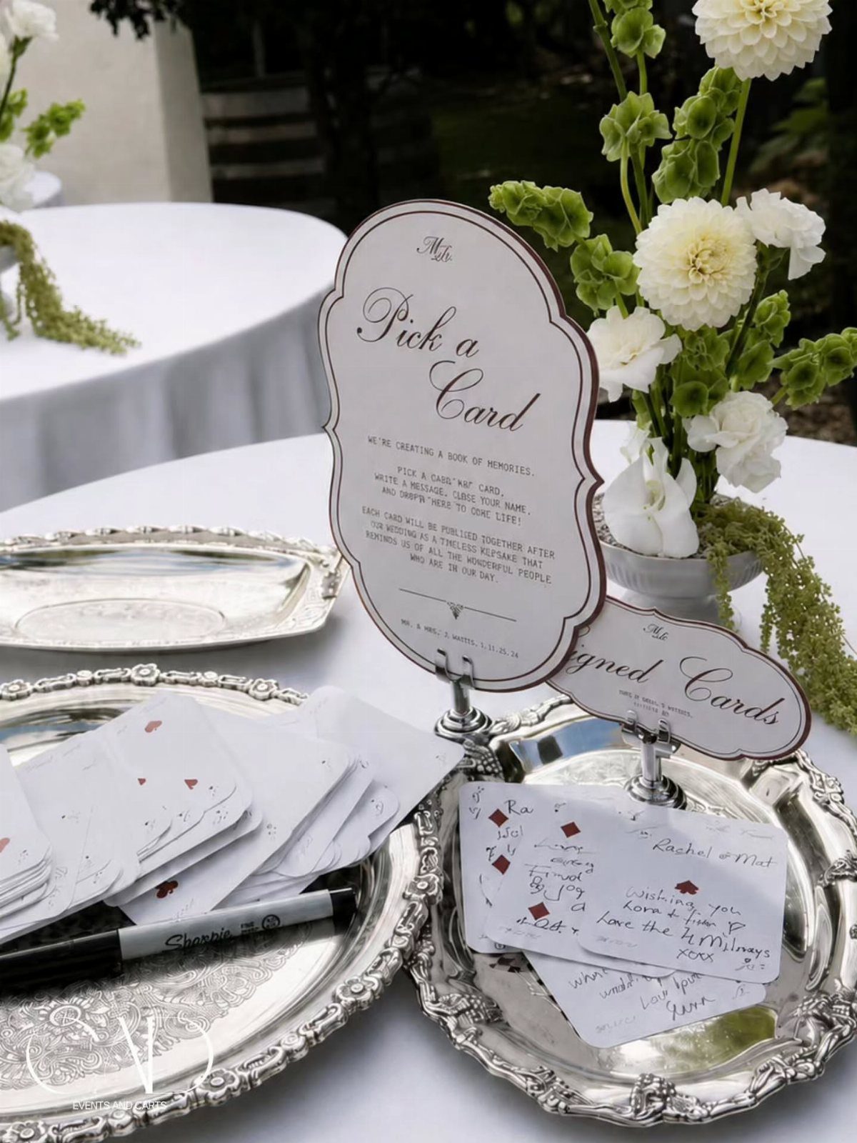 Wedding guest book station with playing card style messages on silver trays.