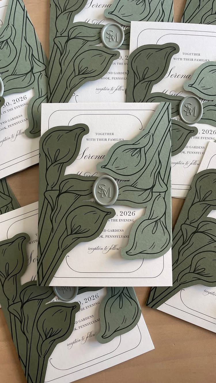 Wedding invitations with sage green hand-painted floral cutouts and circular wax seals.