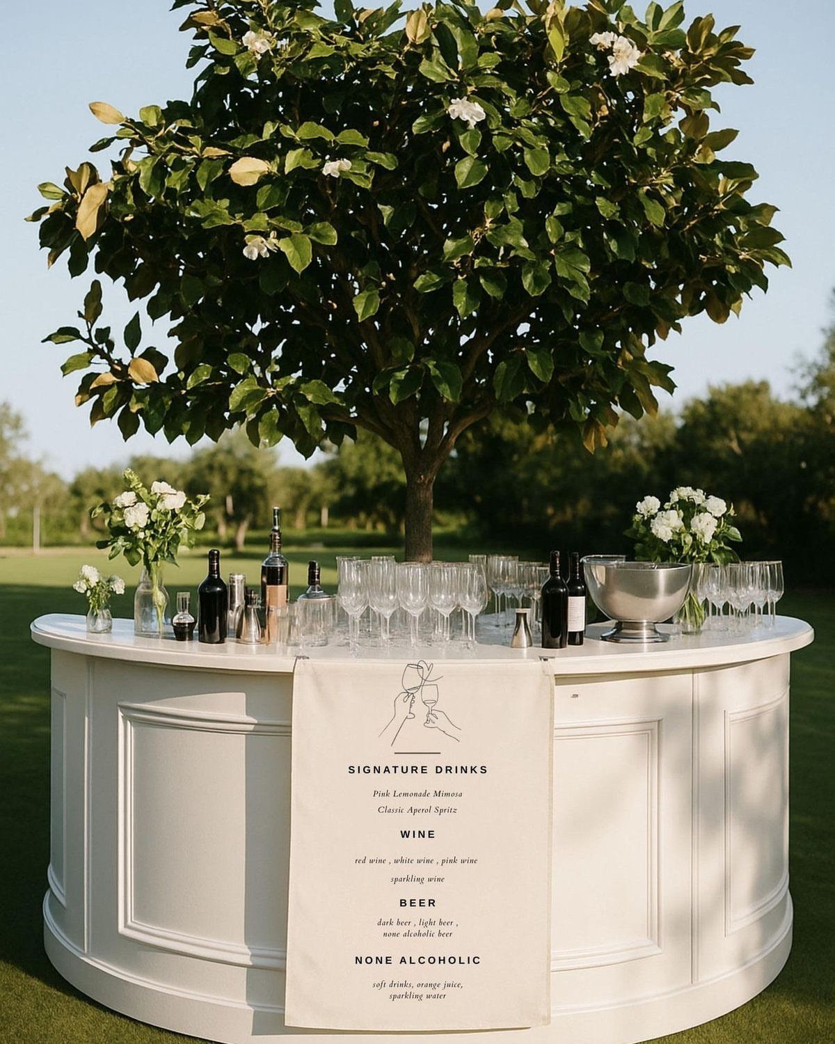 White curved outdoor bar with a signature drinks menu under a green tree