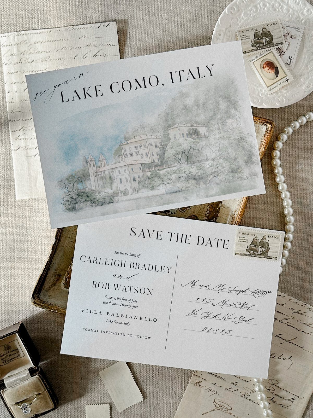Illustrated save the date cards with a watercolor Lake Como scene and pearls.