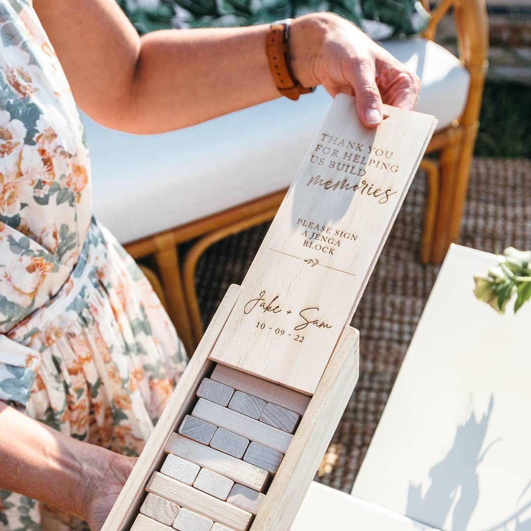 Wooden tumbling block guest book box with engraved wedding message and names.