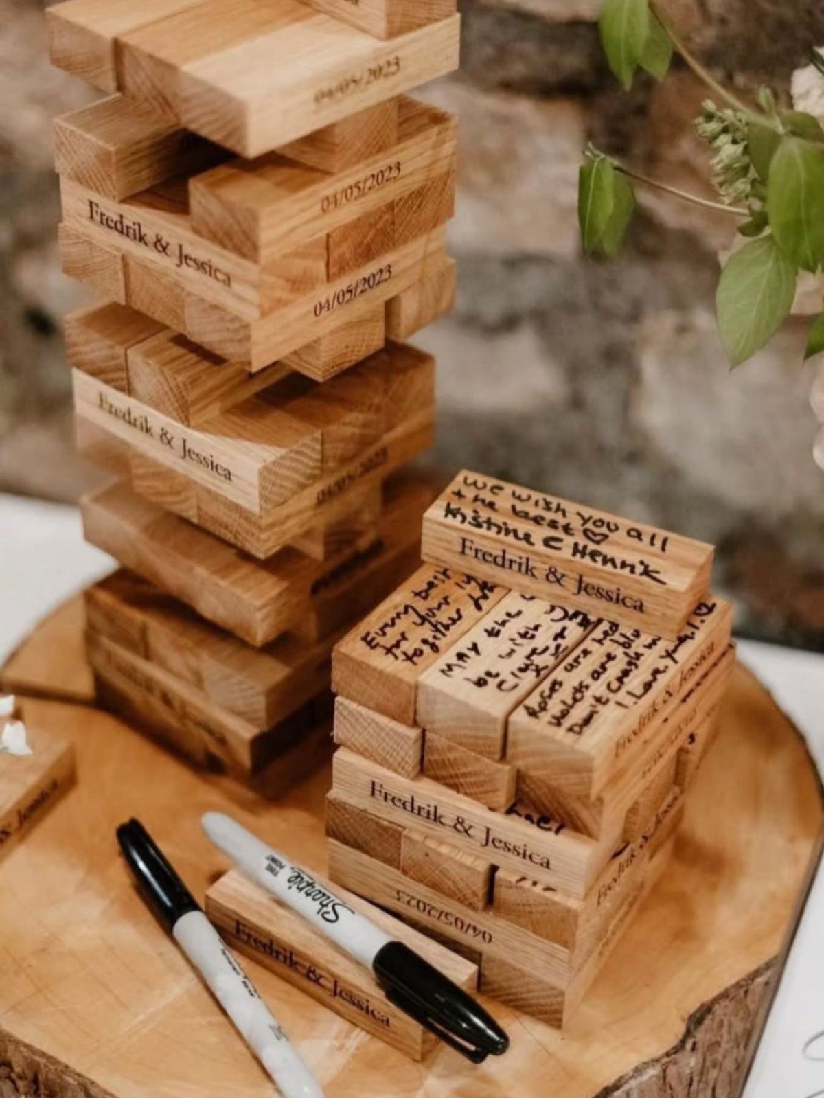 Wooden Jenga blocks with wedding guest messages and names on a wood slice