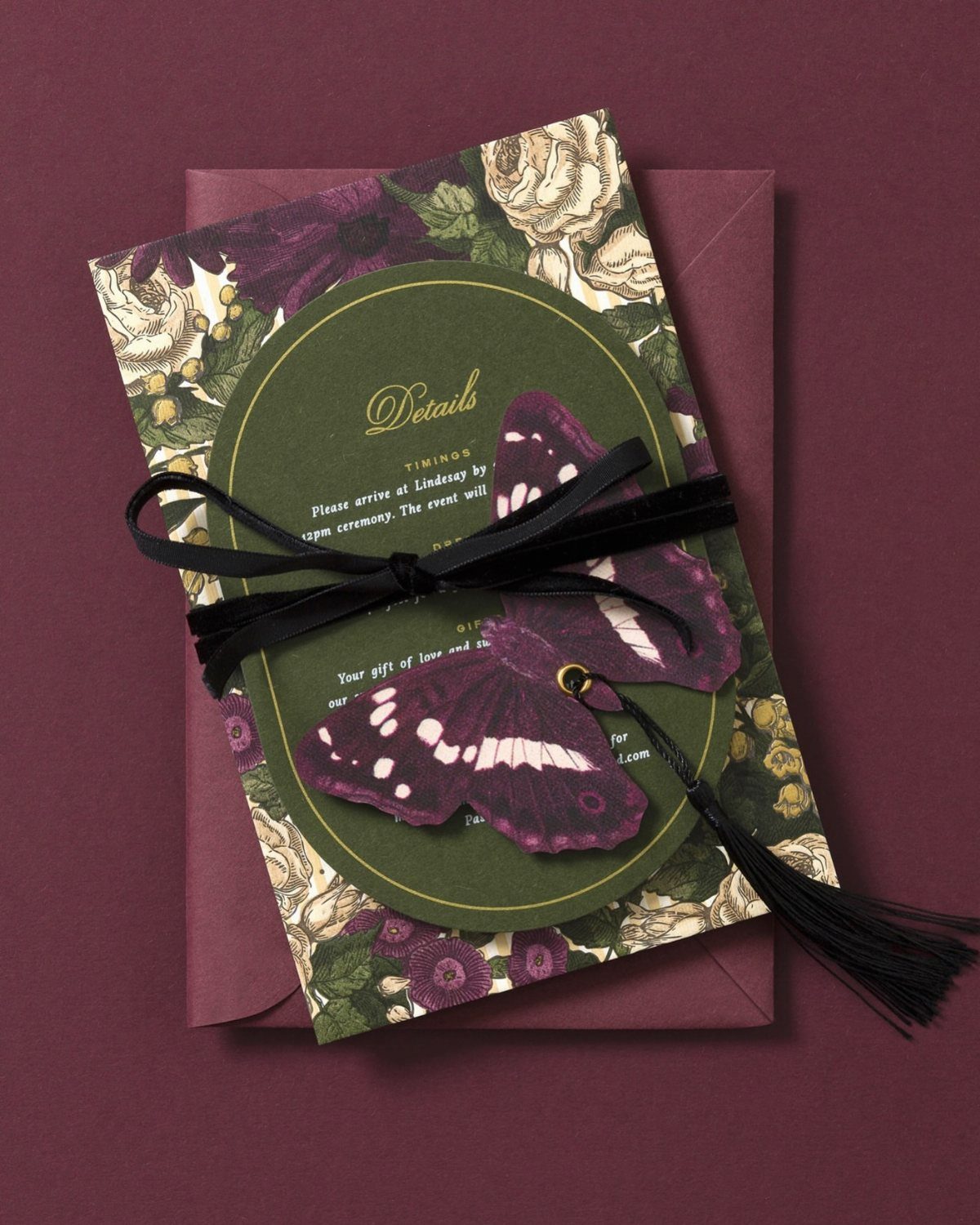 Jewel tone wedding invitation with vintage florals, purple butterfly, and black ribbon tassel.