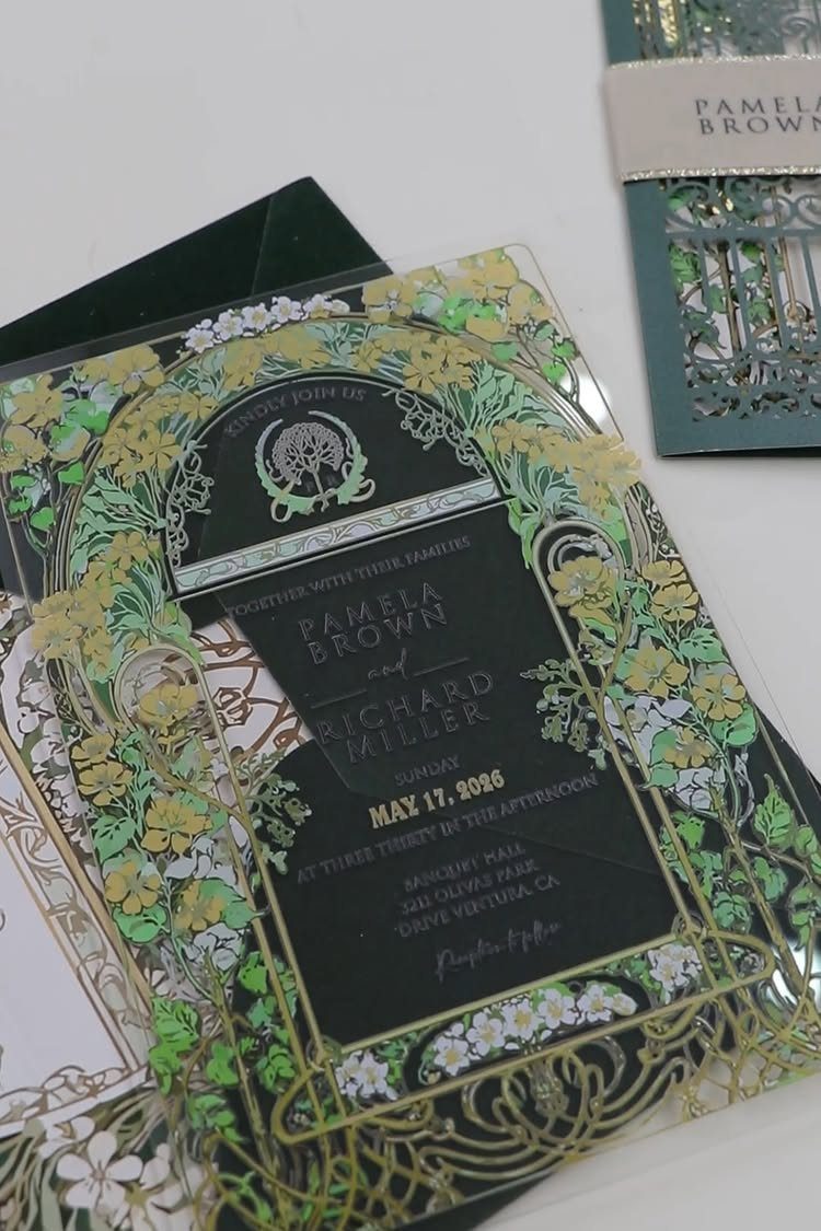 Acrylic wedding invitation with gold and green floral laser-cut patterns and black text.