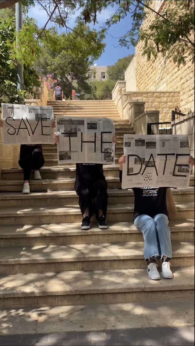 Three people on stone stairs holding newspaper signs that say Save the Date.