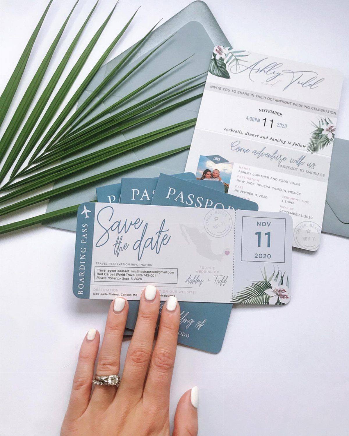Passport-style save the date cards and invitation with a hand wearing an engagement ring.