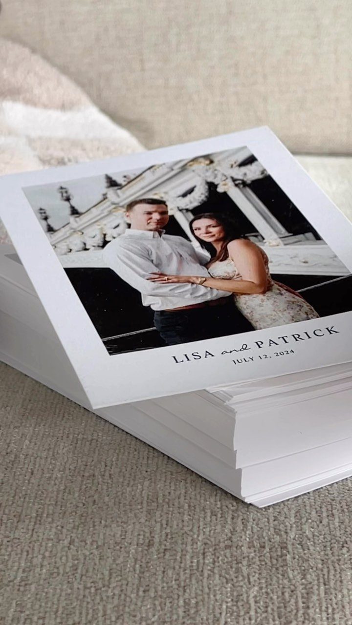 Stack of white save-the-date cards featuring a black and white couple's portrait.