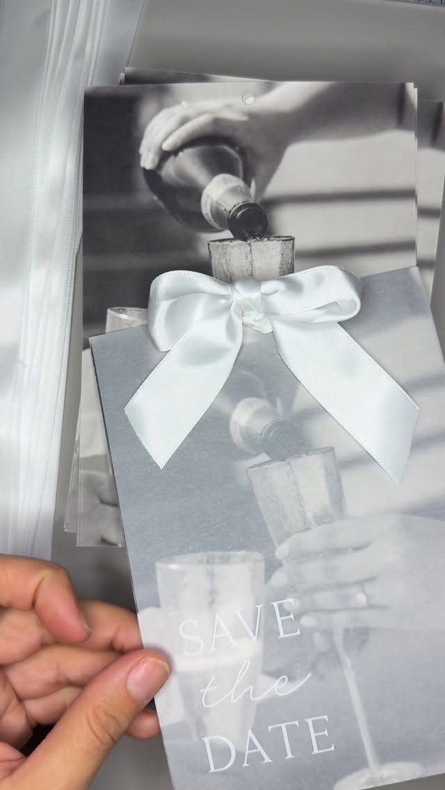 Save the date card with a white bow and black and white photo