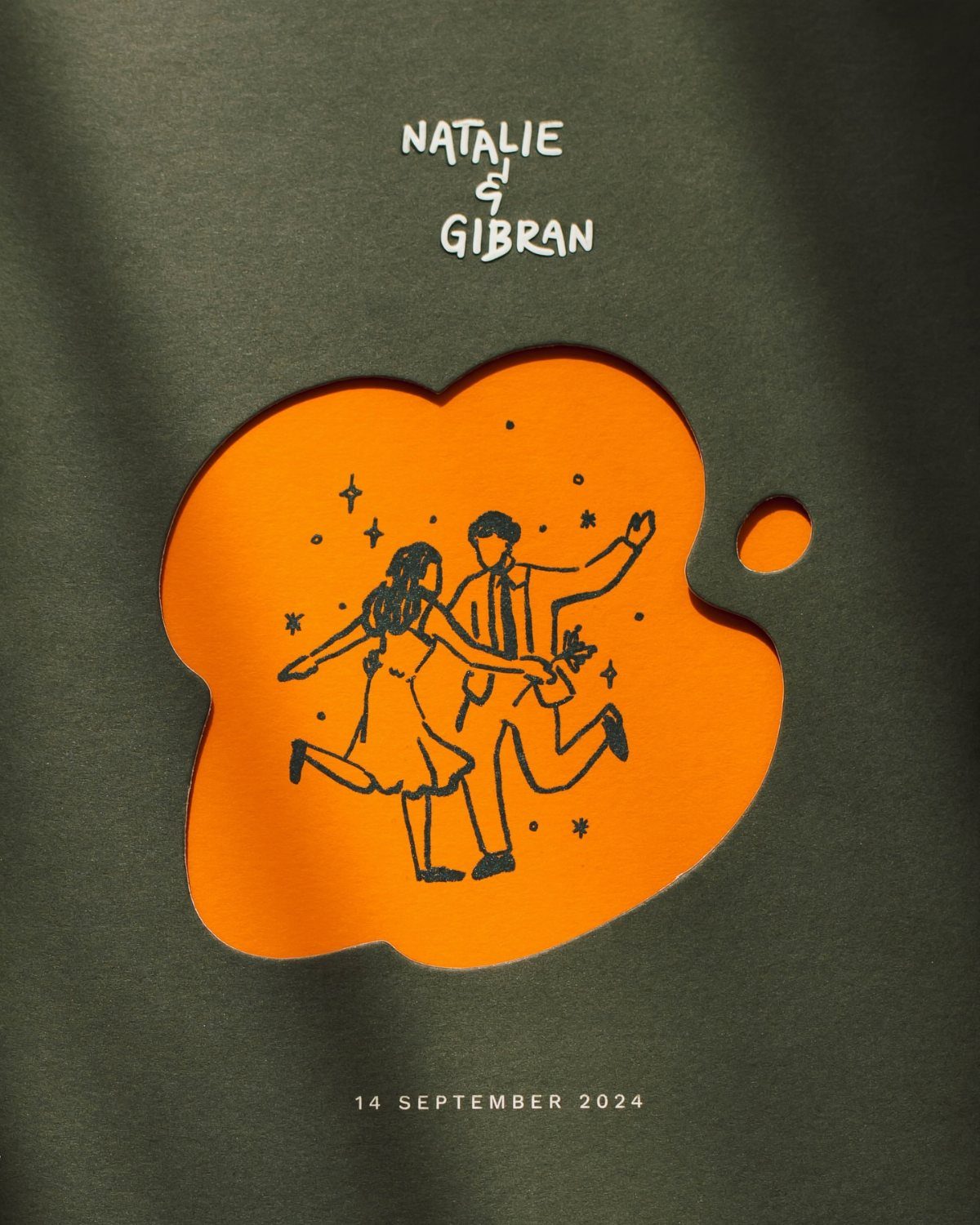 Green wedding invitation with an orange cutout showing a dancing couple illustration.