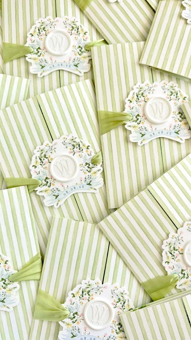 Green and white striped wedding invitations with wax monogram seals and ribbons.