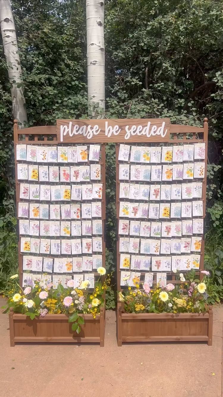 Wooden seed packet display with flowers at the base for wedding guest favors.