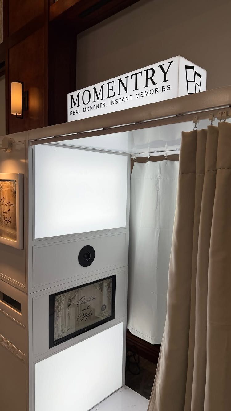 White professional photo booth with a Momentry sign and beige side curtains.