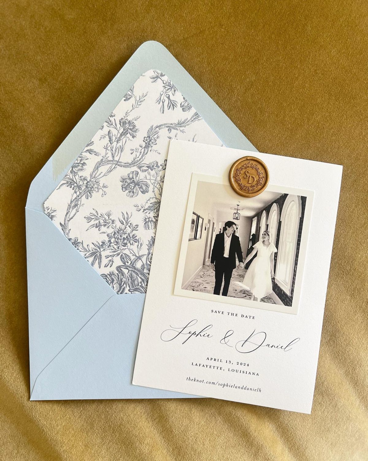 Save the date card with polaroid photo and gold wax seal on blue envelope