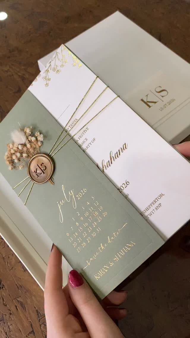 Sage green wedding invitation with gold foil calendar and a gold wax seal.
