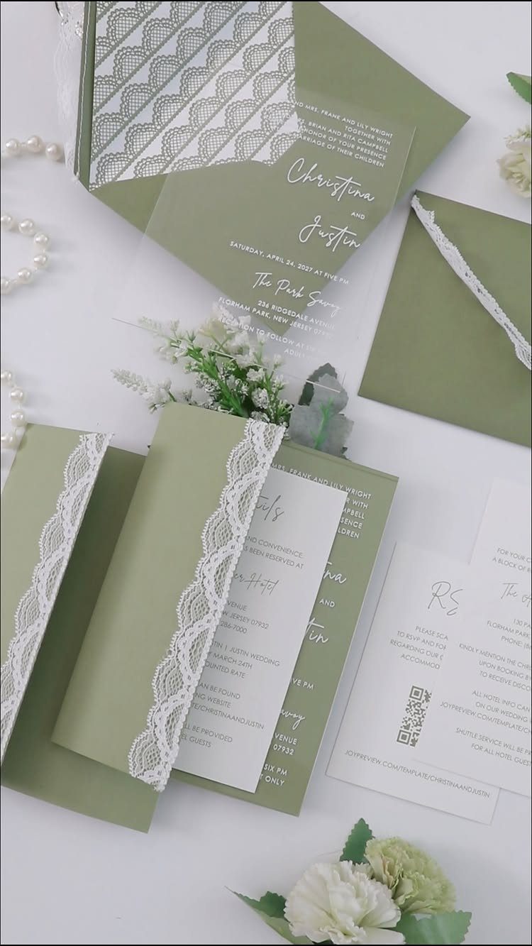 Sage green wedding invitations with white lace trim and delicate white floral accents.