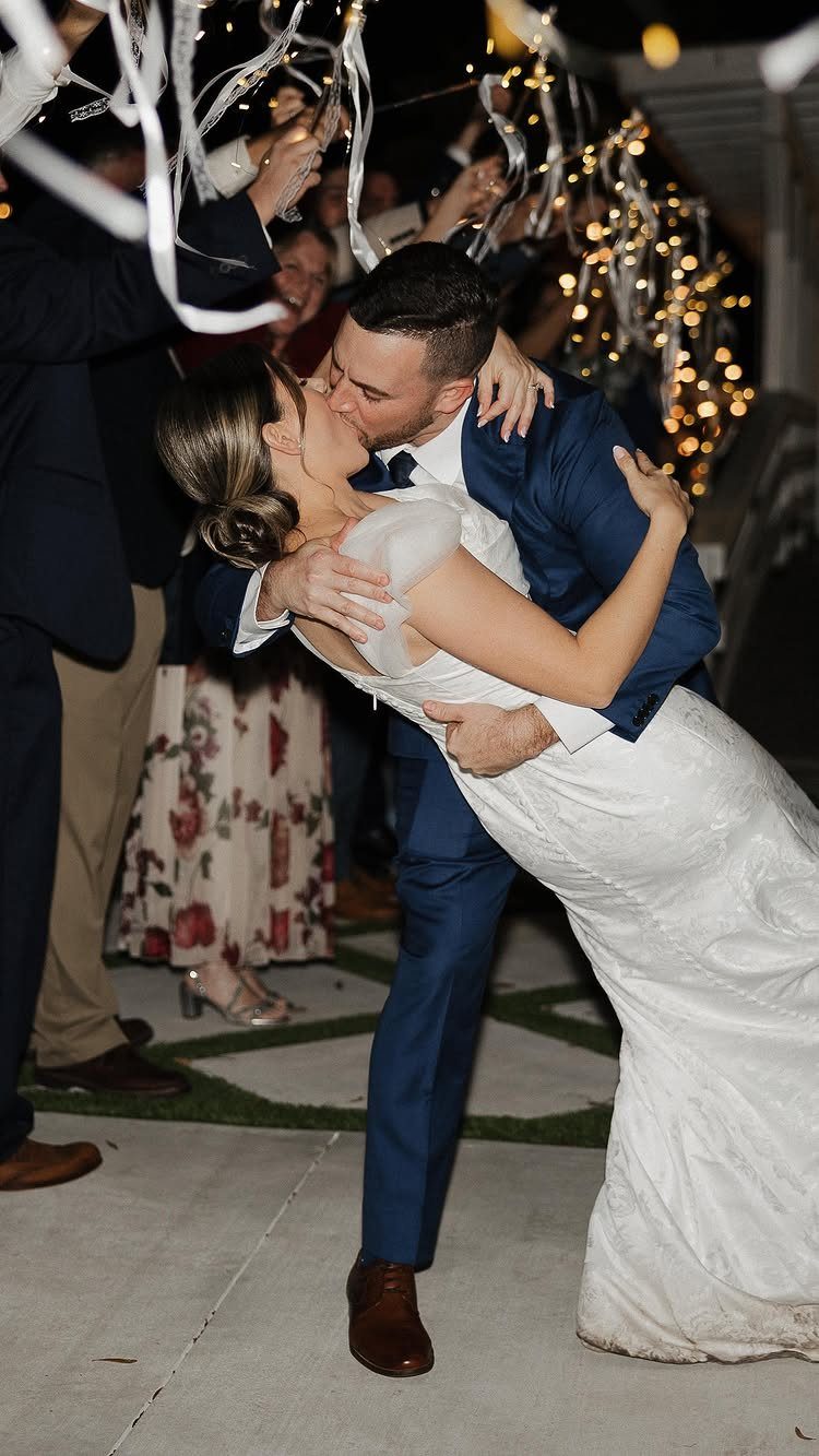 Bride and groom kissing during a ribbon send-off at their wedding reception.